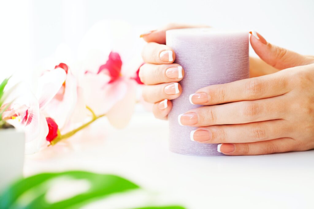 Nails care. Beautiful woman's nails with french manicure, in beauty studio