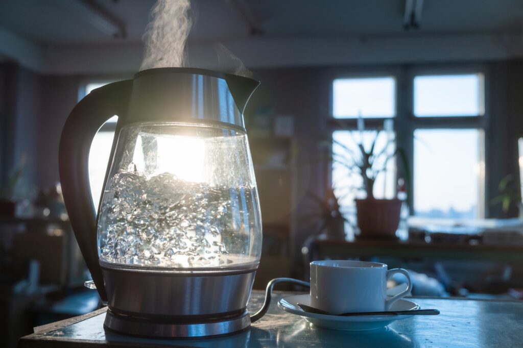 Transparent kettle with water boils