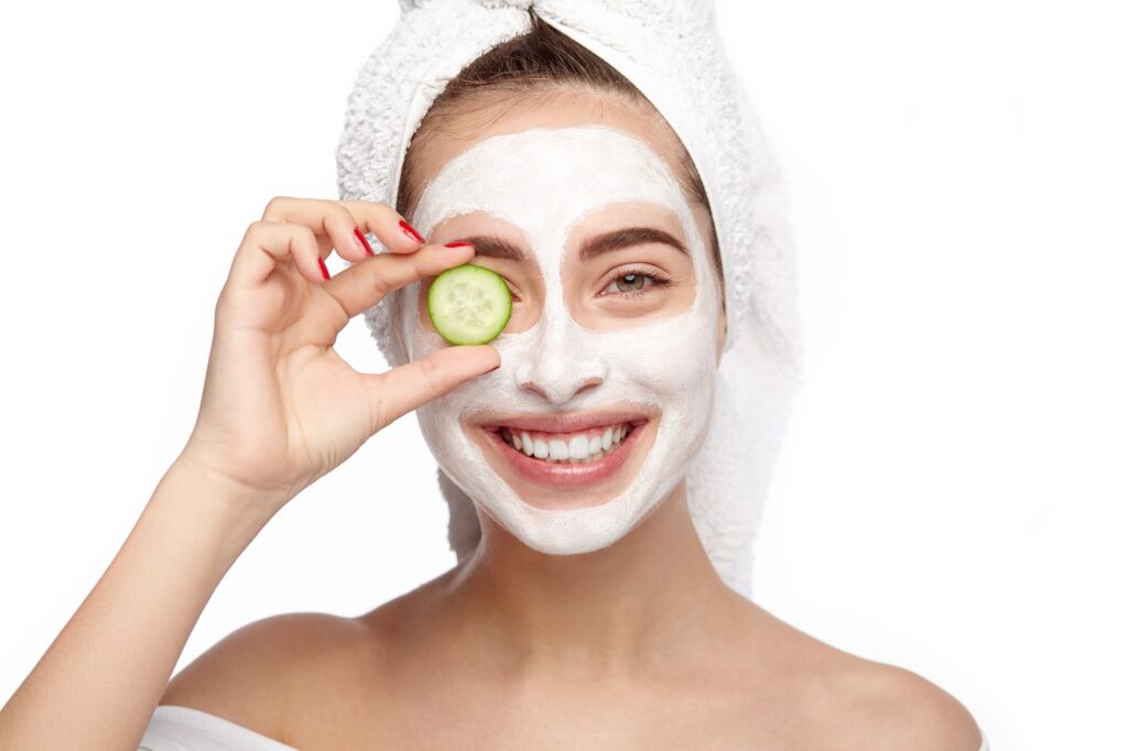 Woman with clay mask and cucumber